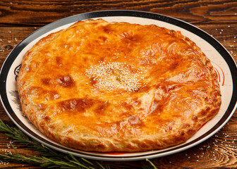 Baked pie with cottage cheese on wooden background