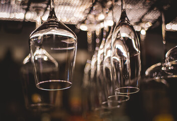 Empty glasses for wine above a bar rack in vintage tone..