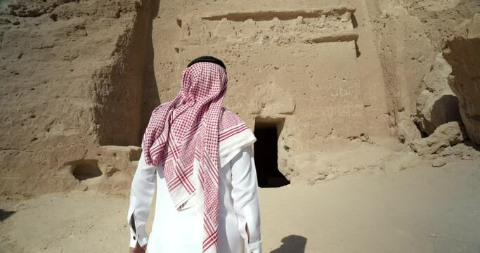 Tracking shot, man walks into Saudi Arabia temple