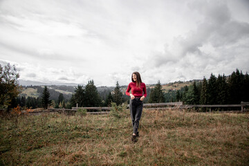 portrait of a young pretty girl who stands alone against a 
background of mountains. beautiful sky, beautiful nature