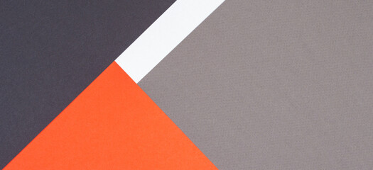 Creative abstract geometric paper background orange, white, light gray, black colors paper. Top view. Copy space
