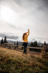 portrait of a young pretty girl who stands alone against a 
background of mountains. beautiful sky, beautiful nature