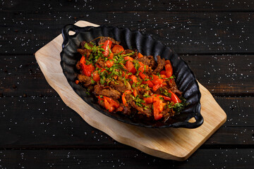 baked meat with vegetables on a wooden background