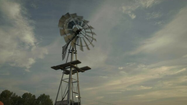 Windmill blows in breeze, low angle