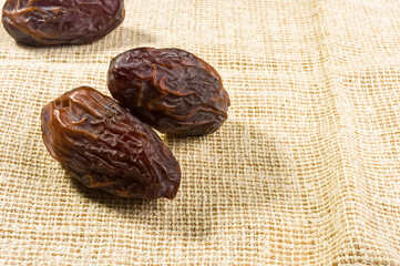 Big luxury dried date fruit on a linen napkin, kurma ramadan kareem concept, close up.