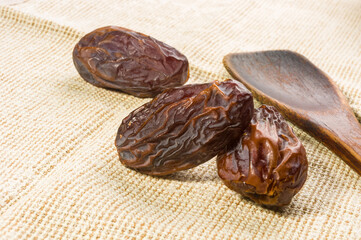 Big luxury dried date fruit on a linen napkin, kurma ramadan kareem concept, close up.