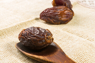 Big luxury dried date fruit on a linen napkin, kurma ramadan kareem concept, close up.