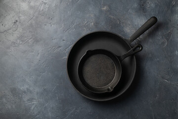 Two cast iron pans on a dark concrete background, place for text