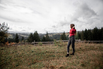 portrait of a young pretty girl who stands alone against a 
background of mountains. beautiful sky, beautiful nature