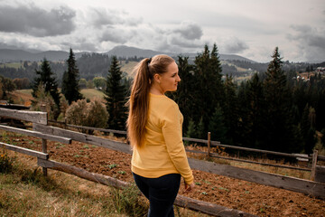 portrait of a young pretty girl who stands alone against a 
background of mountains. beautiful sky, beautiful nature