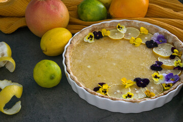 French tart with a lemon flavored filling. Beautiful dessert decorated with wild pansy flowers. 
