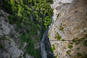 Fototapeta na wymiar Aerial view of river flowing through forest in alpine valley in Switzerland