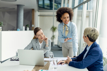 Team of female entrepreneurs communicating while having business meeting in the office.