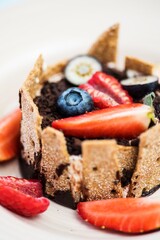 Close up Gourmet dessert with tonka cream, fresh berries and cream, edible soil and finncrisp