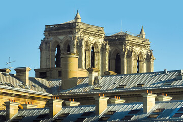 Notre-Dame de Paris, Cathedral of Our Lady of Paris, against the blue sky, roofs historic downtown,...