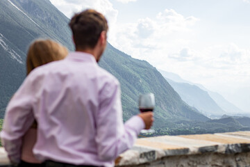 Romatnic couple looking to view while holding wineglasses at front yard