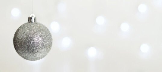 Christmas background with glitter bauble, blurred lights and copy space