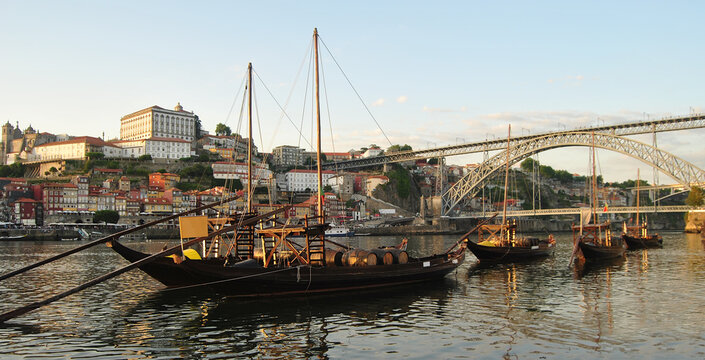 Barcos rabelos parados, ancorados no rio d'ouro no Porto com vista para a baixa da cidade e com a ponte D. Lu&iacute;s de fundo - Engenheiro Eiffel - Transporte de vinhos