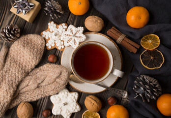 A cup of hot tea in the winter. With tangerines, cinnamon, nuts. Winter still life, new year, christmas.