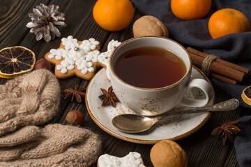 A cup of hot tea in the winter. With tangerines, cinnamon, nuts. Winter still life, new year, christmas.