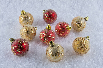 Red and Gold Christmas baubles on snow