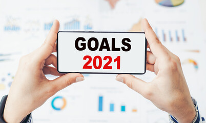 Goals 2021 text on smartphone, goal setting for coming year concept.