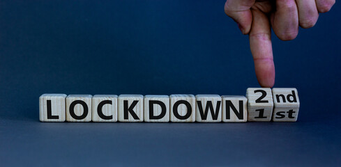 Symbol for a second lockdown. Hand turns cubes and changes the expression 'lockdown 1st' to...