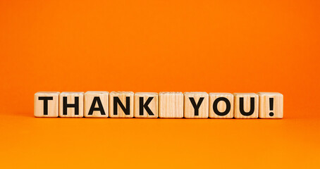 Wooden cubes with the inscription 'thank you'. Beautiful orange background, copy space. Concept.