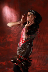 Studio portrate of young female model. Girl with fantasy-style makeup posing against colored background. Fashion photo with futuristic style dress