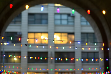 Photo of multicolored garland lights on Christmas Eve on street of Manhattan in New York.