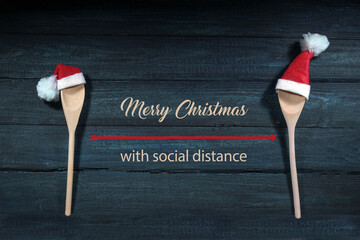 Two cooking spoons with red Santa Claus hats, between them text Merry Christmas with social...
