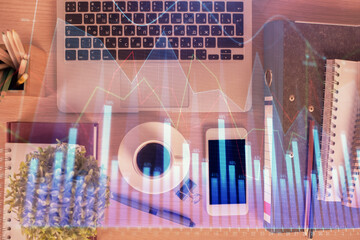 Double exposure of financial graph hologram over desktop with phone. Top view. Mobile trade platform concept.