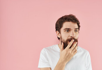 Emotional man on a pink background gesturing with his hands close-up cropped view