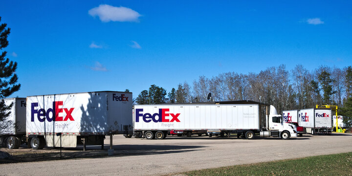 BEMIDJI, MN - 26 APR 2019: A fleet of large FedEx delivery trucks parked at a Federal Express facility on a sunny day.