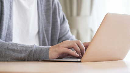 Fototapeta premium リビングでパソコンをする男性