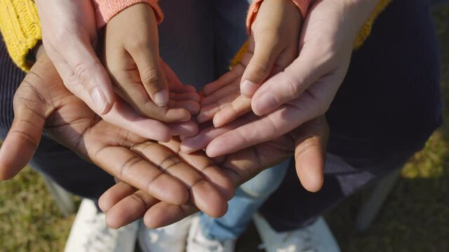 Close up of diverse family hands together outdoors