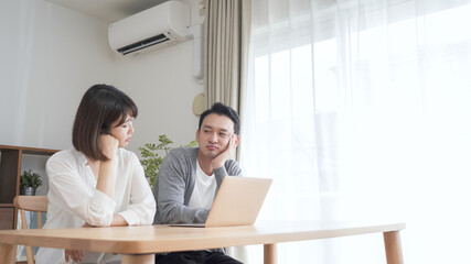 リビングでパソコンを見る夫婦・カップル