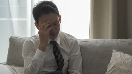 リビングのソファーに座っているビジネスマン