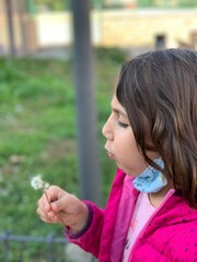 School girl blowing a dandelion