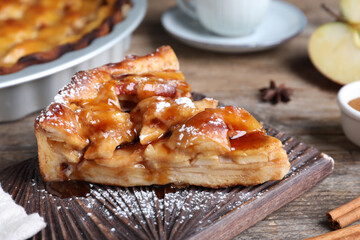 Slice of traditional apple pie served on wooden table, closeup