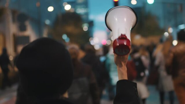 Young woman With Megaphone Walks in the protest crowd. Fights for the equal treatment. High quality 4k footage