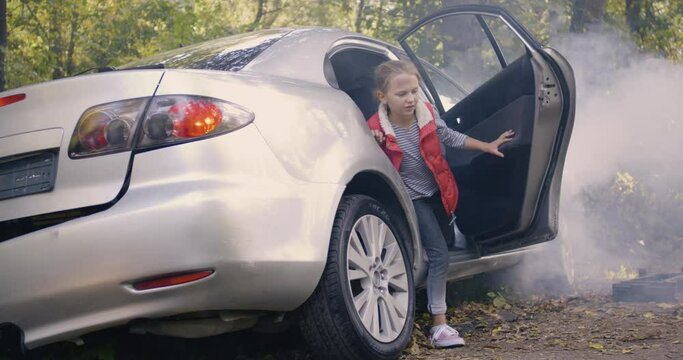 Girl getting out broken car after accident