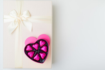 flat lay with pink heart shaped candy box and present box
