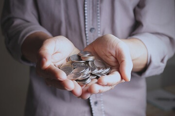 Coins in hands young man in saving money concept.