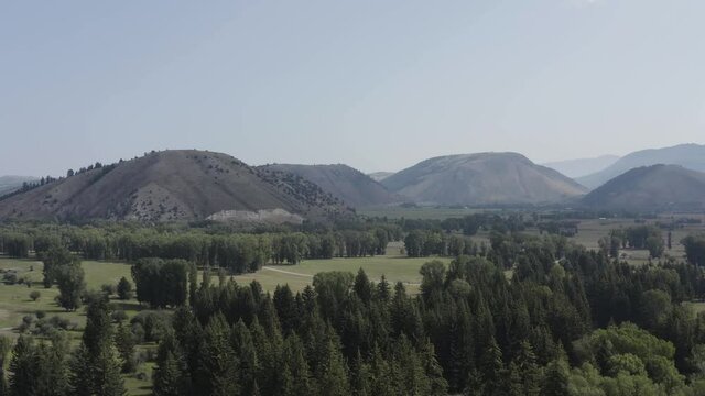 Aerial View of a Forest and Meadow on the Harrison Ford Ranch with Mountain Landscape of Tetons Near Jackson Hole, Wyoming USA