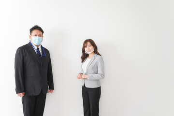 ソーシャルディスタンスを確保し、オフィスで会話をするビジネスパーソン