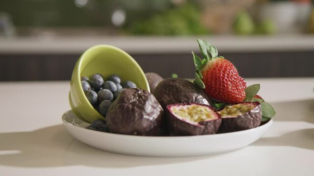 Fresh fruit prepared on bowl on kitchen counter. Passionfruit, blueberry, strawberry - healthy eating 4k