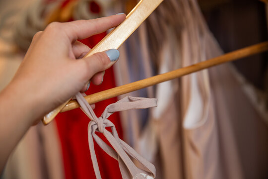 main f&eacute;minine tenant un support en bois avec un morceau de linge accroch&eacute;