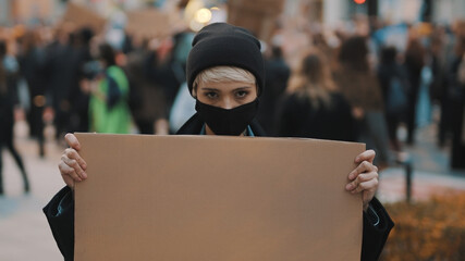 Protest and demonstrations. rebellious woman with face mask striking . High quality photo