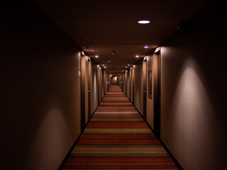 Long corridor avec plusieurs portes et lumières au plafond